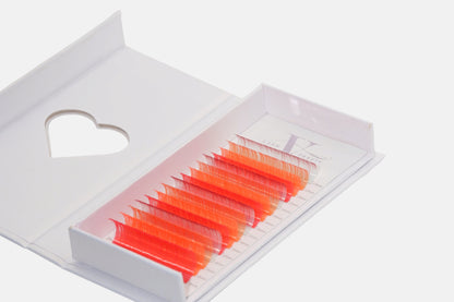 Sunset Glow 0.05mm Colored Lash Extensions featuring coral, neon orange, and hot pink lashes for volume, hybrid, and creative lash designs.

